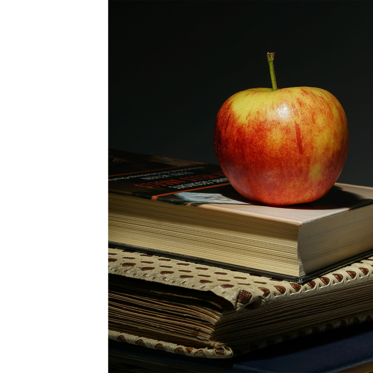 apple sitting on top of books