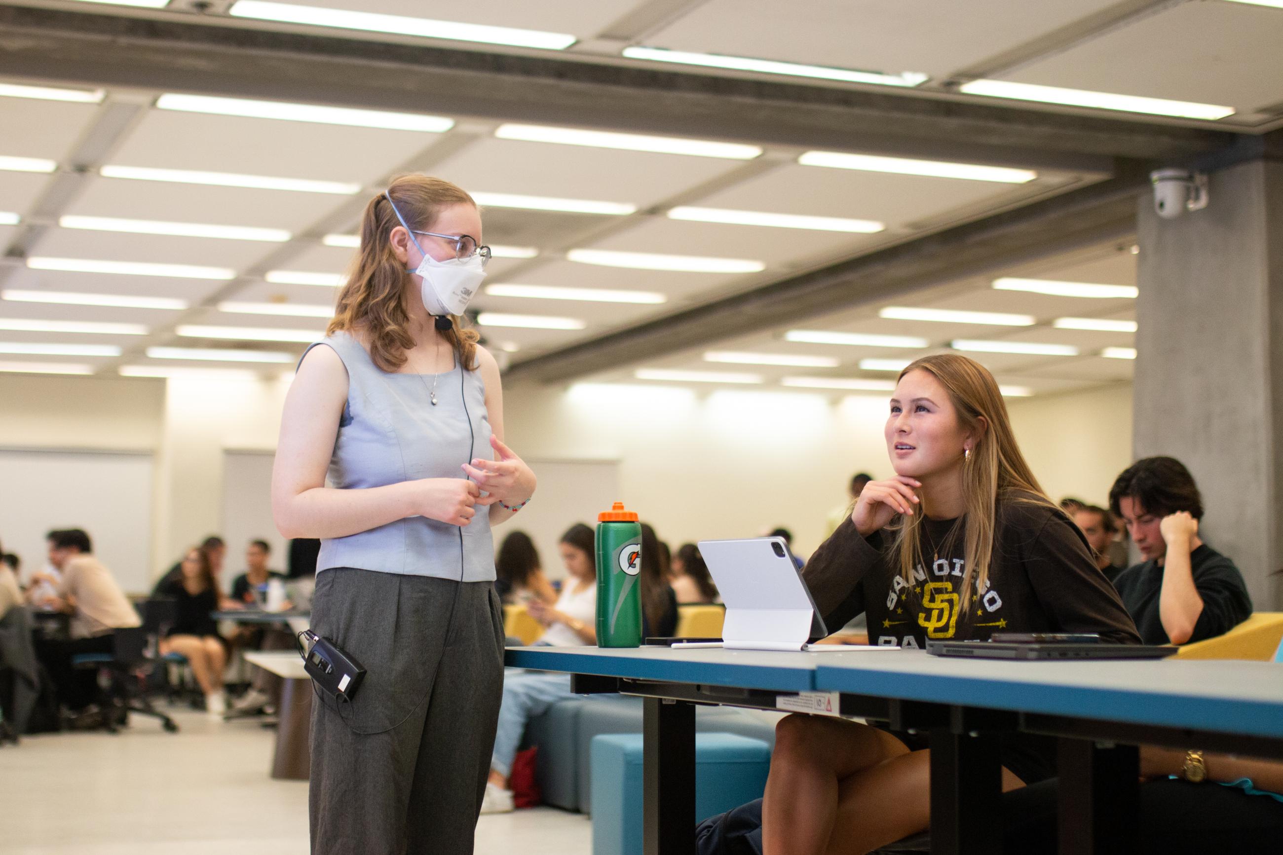 GSI converses with student in UC Berkeley Moffitt Library classroom 