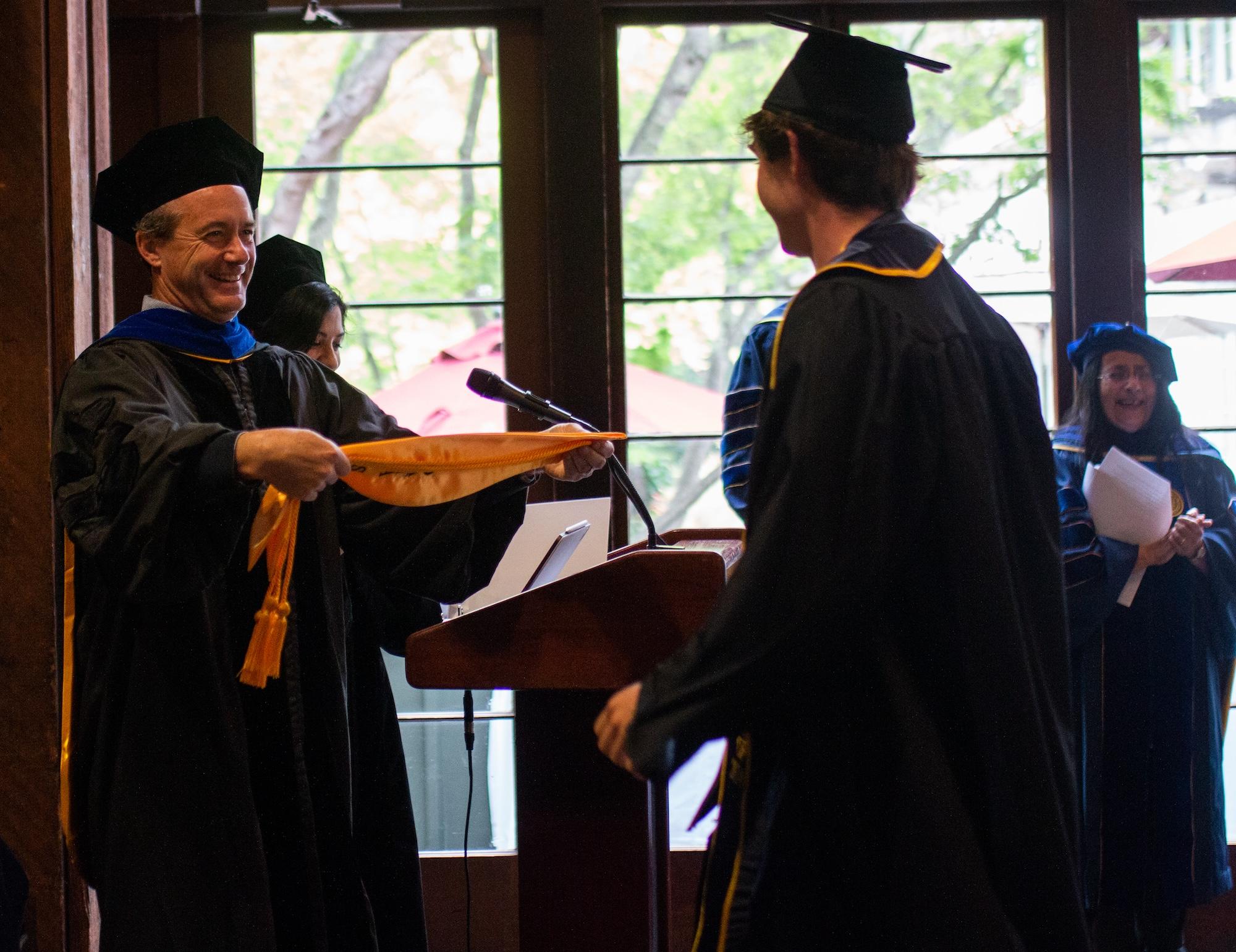 Faculty member, Eric Van Dusen, presents custom stole to honors student at 2024 Data Science Honors Reception