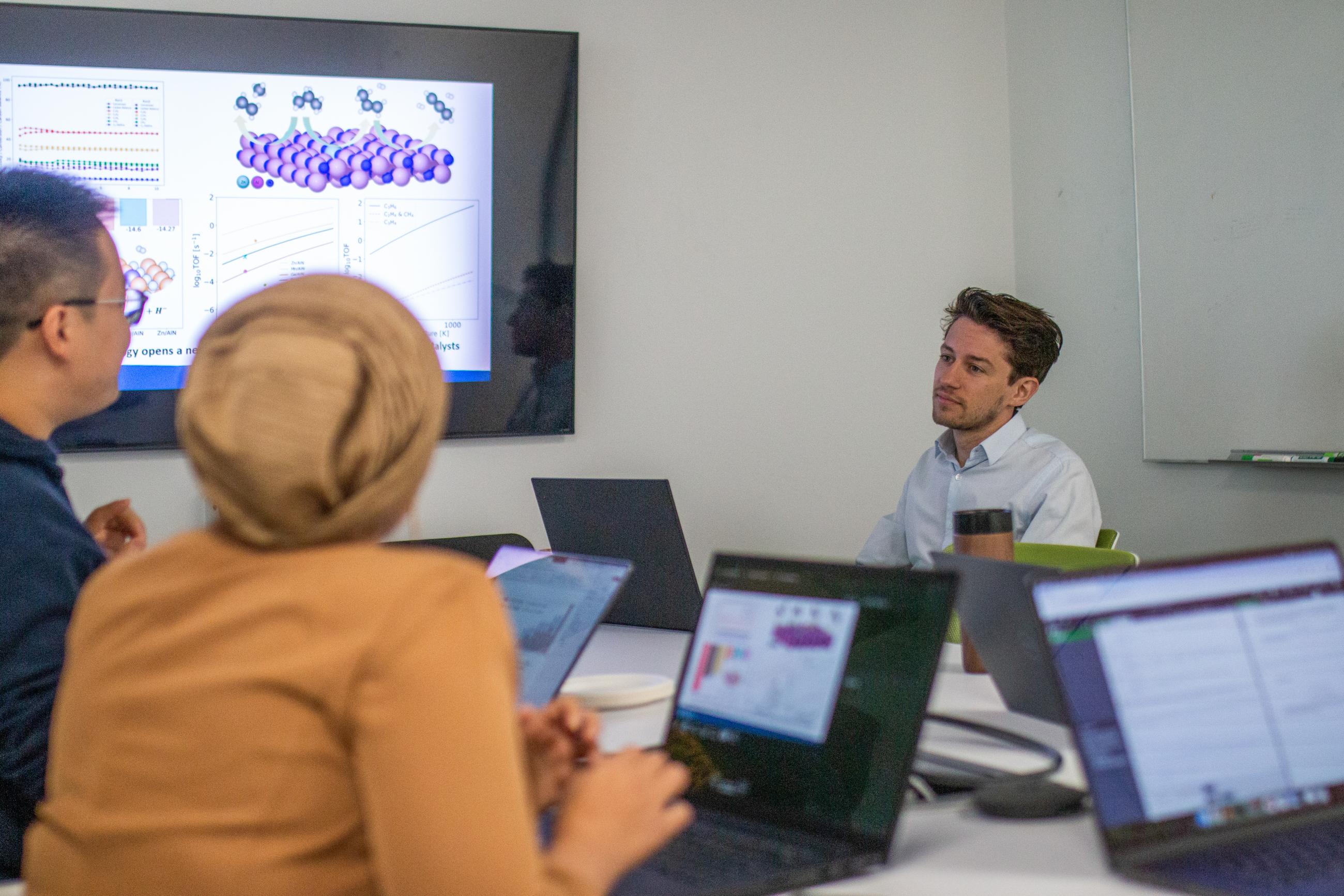 Image of BIDMaP's postdoctoral researchers sitting at a table while meeting