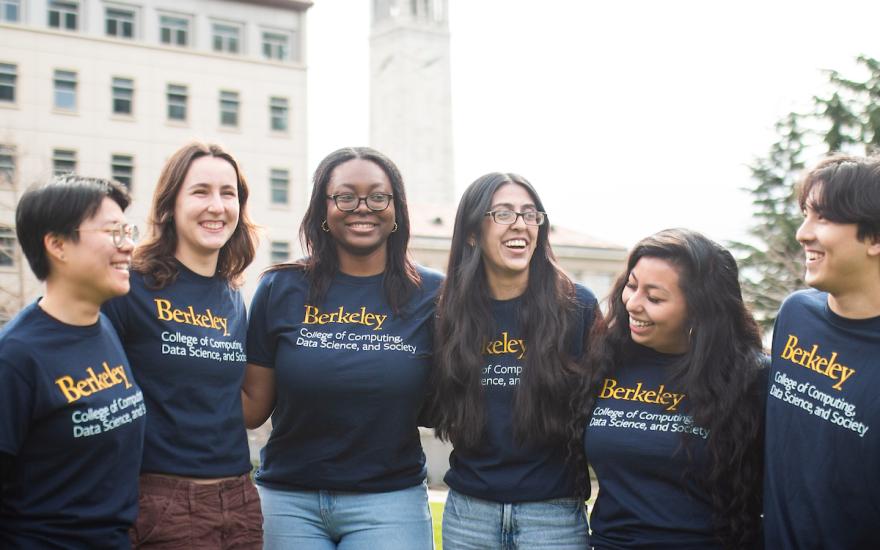 Students smile in front of the Campanile on the UC Berkeley campus.