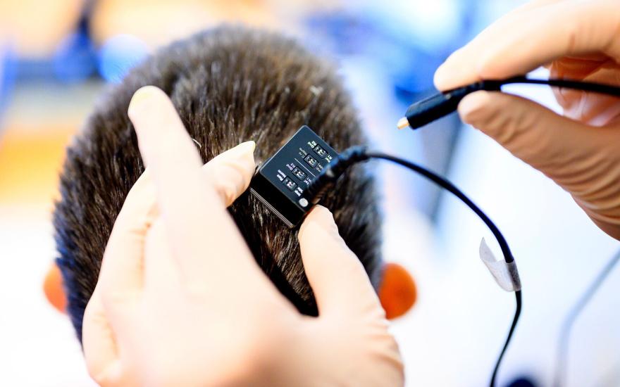 Researchers connect Ann's brain implant to the voice synthesizer computer. (Photo by Noah Berger)